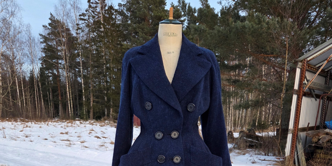 Agnes Vintage Store: marinblå Dior-kappa på docka ute i snömiljö.
